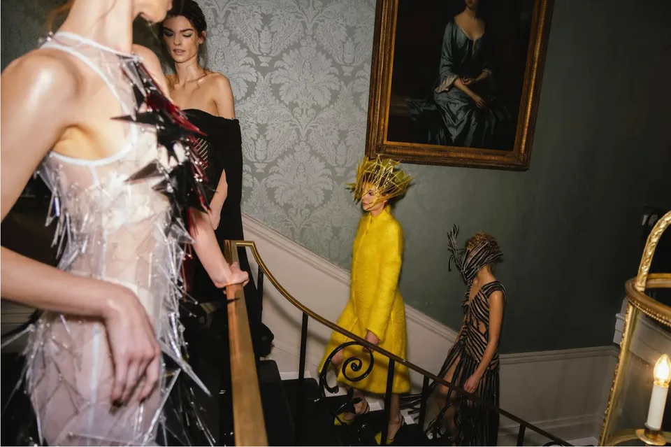 Models wearing Genaro Rivas designs on an interior staircase