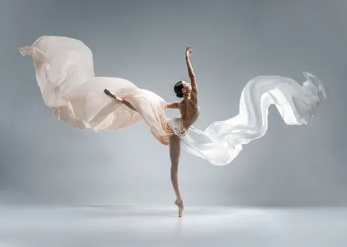 A dancer expressing movement with flowing white fabric